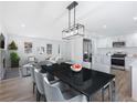Open concept dining area with a black table, gray chairs, and modern lighting at 488 Village Run, Lawrenceville, GA 30046
