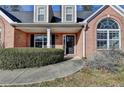Charming brick home featuring an arched window, covered entrance, and well-maintained landscaping at 90 Ashford Dr, Oxford, GA 30054