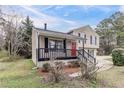 A cozy two-story home showcasing a charming front porch and a well-manicured lawn at 3045 Flat Shoals Rd, Atlanta, GA 30349
