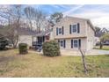 View of a two-story home with light siding and blue shutters surrounded by trees at 3045 Flat Shoals Rd, Atlanta, GA 30349