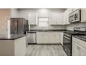 Modern kitchen with stainless steel appliances, granite countertops, and stylish gray flooring at 3045 Flat Shoals Rd, Atlanta, GA 30349