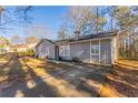 Newly renovated home with gray siding, and a long driveway leading to the front entrance at 1832 Vauxhall Dr, Lithonia, GA 30058