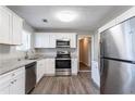 Renovated kitchen with white shaker cabinets, granite countertops, and stainless steel appliances at 1832 Vauxhall Dr, Lithonia, GA 30058