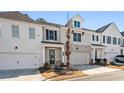 Modern two-story townhome with white and gray exterior, stone accents, and attached garage at 1706 Pardee Dr, Kennesaw, GA 30152