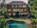 Exterior elevation of a brick home overlooking a backyard pool and patio at 3950 Stanford Dr, Cumming, GA 30041