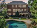 Brick home with a large deck, inground pool, and basketball court at 3950 Stanford Dr, Cumming, GA 30041