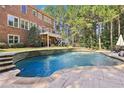 Large, kidney-shaped pool with stone decking at 3950 Stanford Dr, Cumming, GA 30041