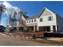 Street view of newly constructed two-story townhomes with varied brick and siding exteriors and drive-in garages at 405 Carrera Ln, Acworth, GA 30102