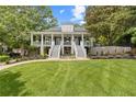 Charming two-story home featuring double staircases, manicured lawn and landscaping, a water feature, and a covered porch at 117 N Cove Dr, Peachtree City, GA 30269