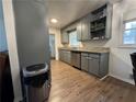 Kitchen featuring stone countertops, stainless dishwasher, wood floors and gray cabinets at 987 Forrest Se Cir, Atlanta, GA 30354