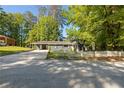 Gray house with white picket fence, driveway, and mature trees at 558 Plainville Dr, Atlanta, GA 30331