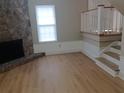Light and bright living room with wood-look floors, a stone fireplace, and a staircase at 701 Boone Ct, Stone Mountain, GA 30088