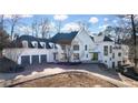 White home with gray roof and three car garage; beautiful landscaping at 1890 W Paces Ferry Nw Rd, Atlanta, GA 30327