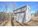 Rear view of house showcasing deck and wooded setting at 509 Ajo Way, Dallas, GA 30157