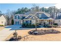 Beautiful blue home featuring an attached two-car garage, a well-manicured lawn, and tasteful landscaping at 4960 Shade Creek Xing, Cumming, GA 30028