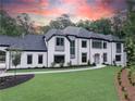 Elegant white brick home with a gray roof and manicured lawn at 5271 Lake Forrest Dr, Atlanta, GA 30342