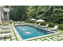 A serene swimming pool surrounded by lounge chairs, umbrellas, and lush landscaping for ultimate relaxation at 3612 Castlegate Nw Dr, Atlanta, GA 30327