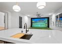 Kitchen island featuring a sink and butcher block, leading to an indoor golf simulator at 4927 Slaton Drive, Acworth, GA 30101