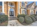 Elegant entryway with double doors, stone flooring, and manicured landscaping at 215 Moss Creek Walk, Fayetteville, GA 30214