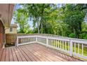 Wooden deck with white railing surrounded by green trees at 2382 Old Rex Morrow Rd, Ellenwood, GA 30294