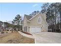Two-car garage with a spacious driveway and a side patio at 610 Ashwood Ct, Woodstock, GA 30189