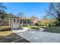 Ranch home with a long driveway, attached garage, and a landscaped yard at 3860 Wisteria Sw Ln, Atlanta, GA 30331