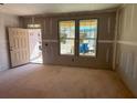 Unfinished living room with new front door and light, view to yard via two large windows at 628 Gilles Ln, Cumming, GA 30041