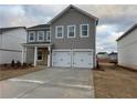 Two-story house with gray siding, white three-car garage, and landscaping at 2125 Boxwood Circle Se, Conyers, GA 30094