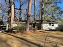 White brick ranch house nestled among tall trees, showcasing a wood-detailed porch at 1863 Bruce Ne Rd, Atlanta, GA 30329