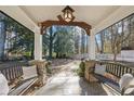 Spacious front porch with two benches, stone flooring and wooded backyard view at 2529 Piney Grove Rd, Loganville, GA 30052