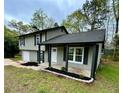 Charming split-level house with a covered front porch, neutral siding, dark trim, and fresh landscaping at 5507 Flat Shoals Pkwy, Decatur, GA 30034