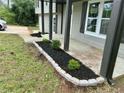 Close-up of the front porch landscaping with fresh black mulch and a gray stone border at 5507 Flat Shoals Pkwy, Decatur, GA 30034