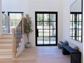 Bright entryway with stylish bench, light wood floors, and modern staircase at 1240 Spalding Dr, Sandy Springs, GA 30350