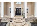 Elegant home entrance featuring a stone pathway and pillars with a decorative double door at 1350 Eryn Cir, Suwanee, GA 30024