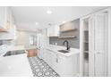 Modern white kitchen with hexagon floor tile, quartz countertops, and gold accents at 18 Ivy Ne Rdg, Atlanta, GA 30342