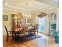 Elegant dining room featuring hardwood floors, chandelier, and large window at 651 Hexham Ct, Suwanee, GA 30024