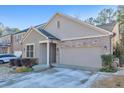 Tan two-story home with a two-car garage and manicured landscaping at 630 Eagles Lndg, Woodstock, GA 30188