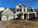 Two-story house with gray siding, two-car garage, and stone accents at 681 Courageous Ct, Lawrenceville, GA 30043