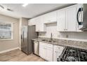 Modern kitchen with white cabinets and stainless steel appliances at 6602 Crossing Creek Pt, Austell, GA 30168