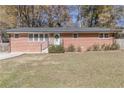 Single-story brick home with a manicured lawn and updated landscaping at 2575 Baker Nw Rd, Atlanta, GA 30318