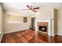 Living room with hardwood floors, fireplace, and ceiling fan at 459 Pleasant Way, Temple, GA 30179