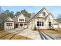 An inviting white home has multiple windows, a side-entry garage and a concrete driveway at 101 Forsyth Park Ln, Woodstock, GA 30188