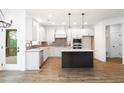Modern kitchen with white cabinets, stainless appliances, and dark island at 1020 Cottonwood Ln, Loganville, GA 30052