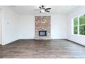 Bright living room features a brick fireplace, ceiling fan and large windows at 1020 Cottonwood Ln, Loganville, GA 30052