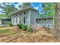 Side view of the gray home showcasing well-maintained landscaping with vibrant purple flowers at 6360 Ashdale Dr, Atlanta, GA 30349