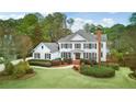 Spacious two-story home with a large yard and surrounding trees at 5060 Rosedown Pl, Roswell, GA 30076