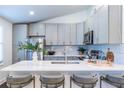 Kitchen featuring white quartz countertops, stainless steel appliances, and barstool seating at 116 Turman Se Ave, Atlanta, GA 30315