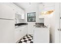 Galley kitchen boasts checkerboard floors, white cabinets, and sleek black countertops at 320 3Rd Ne St # 1, Atlanta, GA 30308