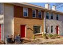 Two-story townhome with red door and brick facade at 242 Chads Ford Way, Roswell, GA 30076