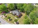 Aerial view of a red brick home with a gray roof, surrounded by lush greenery and mature landscaping at 1420 Arblay Pl, Loganville, GA 30052